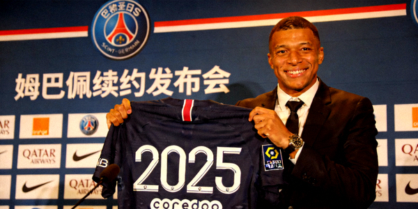 姆巴佩续约巴黎圣日耳曼新闻发布会现场 - 姆巴佩手持印有2025字样的球衣微笑